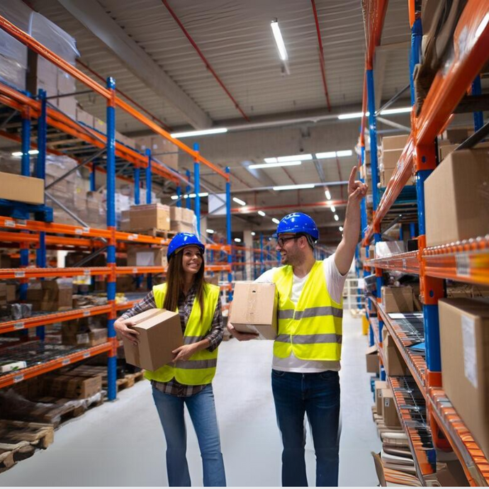 2 warehouse employees are placing goods onto the corresponding shelves